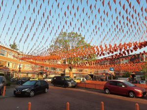 Oranje straatversiering met vlaggenlijnen en slingers voor Koningsdag